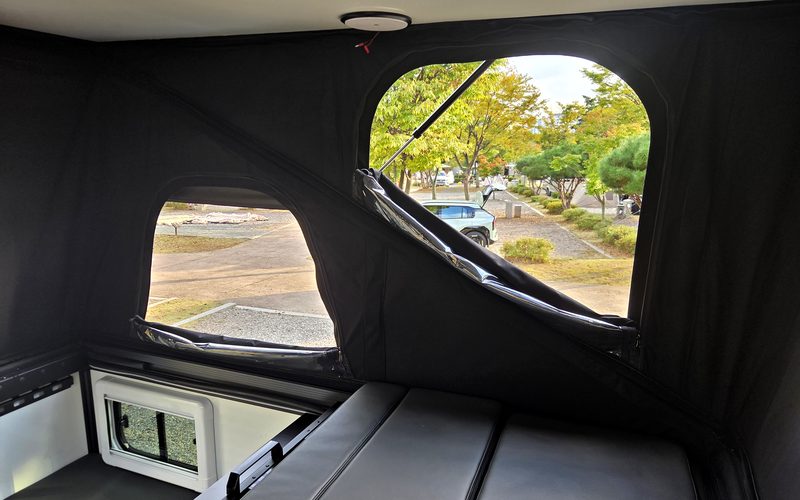Interior with a tent window rolled up, and the bed mattresses