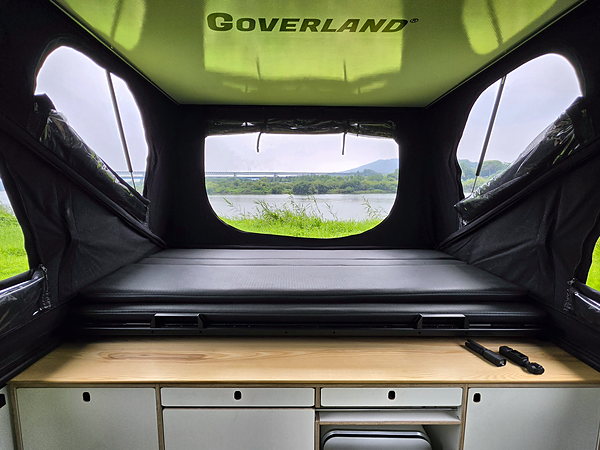 Inside a GOAT with the tent up — bed and storage cabinets